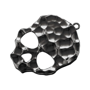 Detail of a vintage black metal skull pendant featuring a unique hammered textured finish