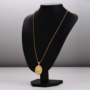 Golden necklace with a 3D religious relief pendant on a professional black bust mannequin