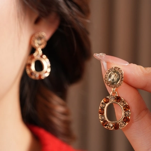 Detailed close-up of vintage gold hollow round earrings with champagne crystals and rhinestones