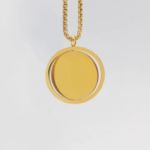Macro detail of a rotating double-layer golden circular pendant on a braided chain necklace