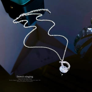 Close-up of D-letter pendant necklace with round zircon on sleek black background