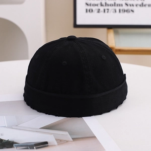 Solid black cotton docker cap with distressed edges for a vintage streetwear aesthetic