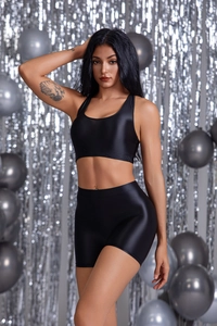 Dettaglio del set da yoga nero lucido con top a vogatore e pantaloncini aderenti slim