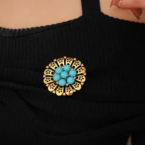 Vintage gold hollow flower brooch with turquoise beads and pink rhinestones on black fabric