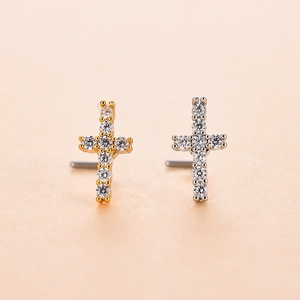 Macro view of gold and silver cross nose studs with micro-pave cubic zirconia crystals