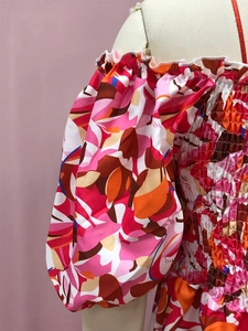 Detalle de vestido bohemio floral con estampado rosa y naranja y diseño de manga puff