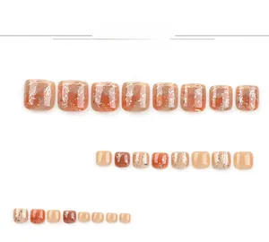 Macro view of amber caramel press-on toenails with glitter and artistic marbling