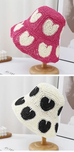 Detailed view of hand-woven straw bucket hat featuring sweet crochet heart patterns