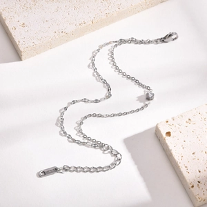 Macro detail of silver stainless steel chain with a sparkling cubic zirconia stone charm