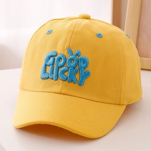 Gros plan sur la broderie bleue GOOD LUCKY d'une casquette en coton jaune pour enfants