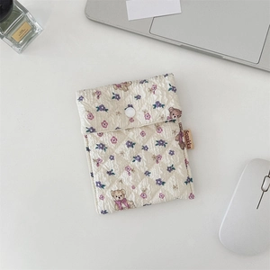 Detail of quilted cotton sanitary bag with cute bear pattern and secure button closure