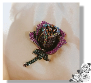 Detailed close-up of retro rose brooch with rose red rhinestones and champagne gems