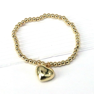 18k gold plated beaded stretch bracelet featuring a polished heart pendant on white background