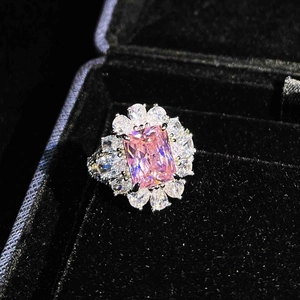 Detailed macro view of pink square gemstone ring with floral halo on black velvet