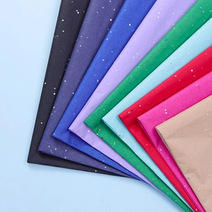 Close-up of multicolored glitter tissue paper sheets arranged in a decorative fan shape