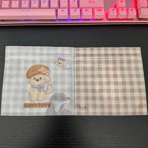 Detail of self-sealing bags with brown checkered pattern and cartoon happy puppy design