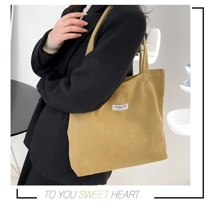 Detail of canvas tote bag with 'Fashion Instinct' patch and sturdy shoulder straps