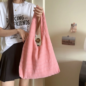 Detailed close-up of pink pleated fabric texture on a large capacity tote shoulder bag