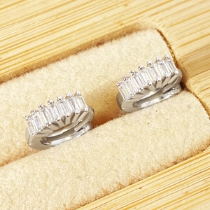 Macro shot of silver-colored earrings with rectangular cubic zirconia in a velvet box