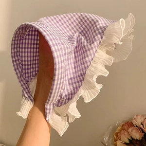 Detail of baby sun hat with purple gingham pattern and white ruffled lace trim edges