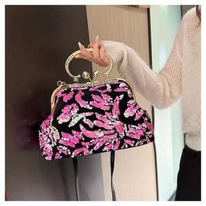 Detail of pink and black sequin shell bag with heart-shaped clasp and metal handle