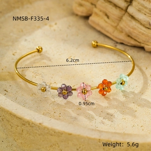 Dettaglio di un bracciale a fiori dorato con perline di zircone e misure del prodotto