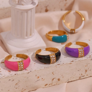 Detail of colorful enamel open rings with crystal rhinestones on marble surface
