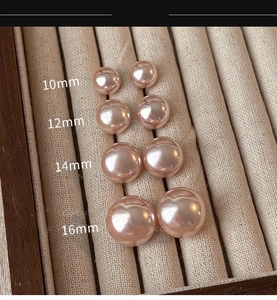 Detail of light pink pearl earrings in sizes 10mm to 16mm on a velvet display stand