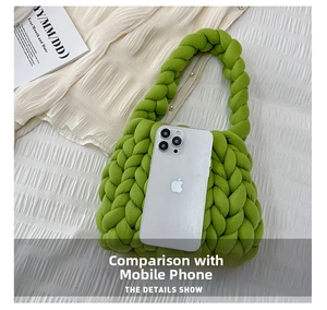 Detail of green chunky knit handbag showing size comparison with a smartphone