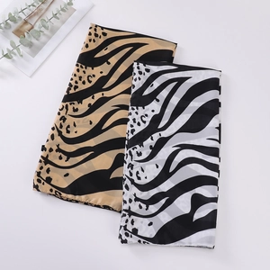 Flat lay of lightweight leopard print scarves in brown and black on white surface