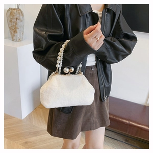Faux fur handbag with pearl handle shown on model wearing leather jacket and brown skirt