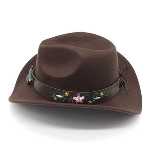 Détail du chapeau de cowboy marron avec broderie florale et breloque en métal