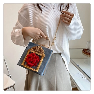 Close-up of vintage baroque handbag with 3D rose and golden relief frame detail