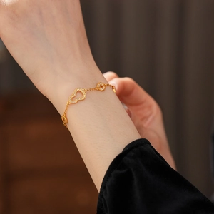 Detail view of a 24k gold plated gourd bracelet with white zircon pavé on a female wrist