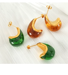 Detail of C-shaped emerald and amber resin stud earrings with 18K gold-plated base