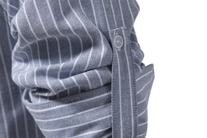 Macro shot of blue and white striped shirt sleeve showing fabric texture and roll-up button