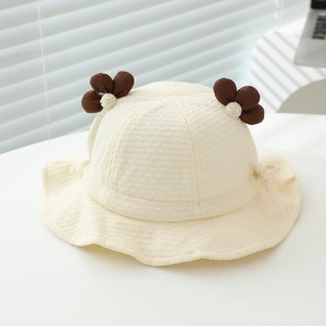 Detail view of cream infant sun hat featuring 3D brown flowers and waffle texture