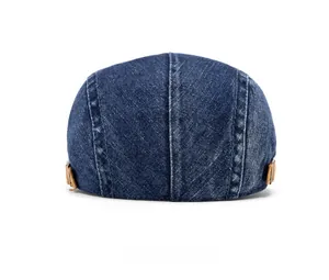 Close-up of the back of denim ivy cap with brown leather side straps and metal buckles