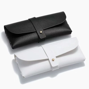 Minimalist black and white pebble grain leather eyewear cases with gold metal stud closure