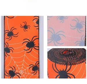 Macro detail of Halloween orange ribbon featuring black spider and white web patterns