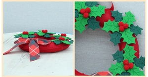 Detail of handmade Christmas felt wreath with holly leaves and red plaid bow tie