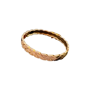 Quilted rose gold bangle featuring elegant diamond-set accents and a polished metal finish