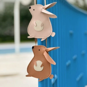Detail of cute rabbit crossbody bags in pink and brown with fine stitching for kids