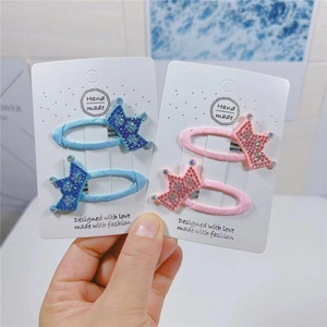 Detailed view of handmade sparkling rhinestone crown hair clips in blue and pink sets