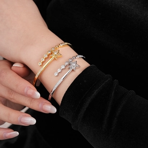 Detail view of gold and silver plated star bracelets with cubic zirconia on a wrist