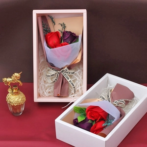 Detail of red and purple soap flower bouquets in pink and white gift boxes with ribbons
