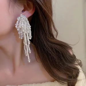 Boucles d'oreilles baroques avec perles blanches et cristaux portées par un mannequin
