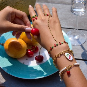 Lush summer jewelry set featuring 18K gold cherry enamel bracelets and pearl rings