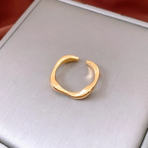 Detail of 18k gold plated irregular wavy open ring with a polished mirror finish surface