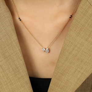 Elegant gold necklace with round and teardrop crystals and black beads on a model